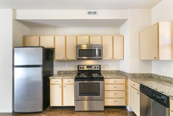 A kitchen with a stainless steel refrigerator, microwave, oven, and dishwasher.
